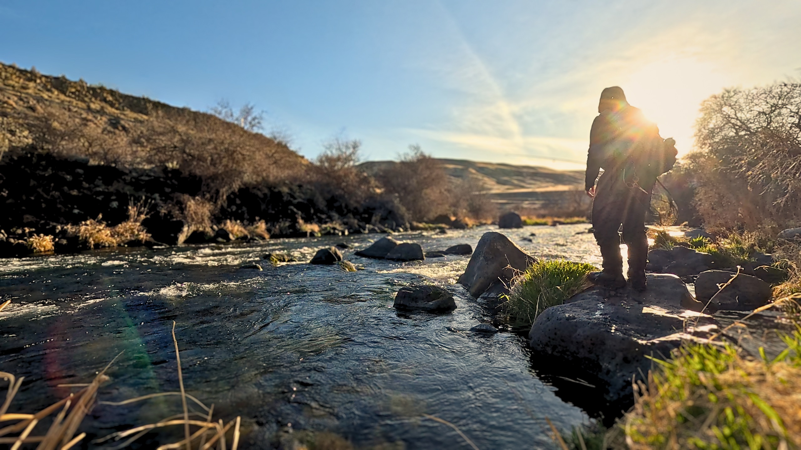 Fly fishing on a coldwater stream at golden hour